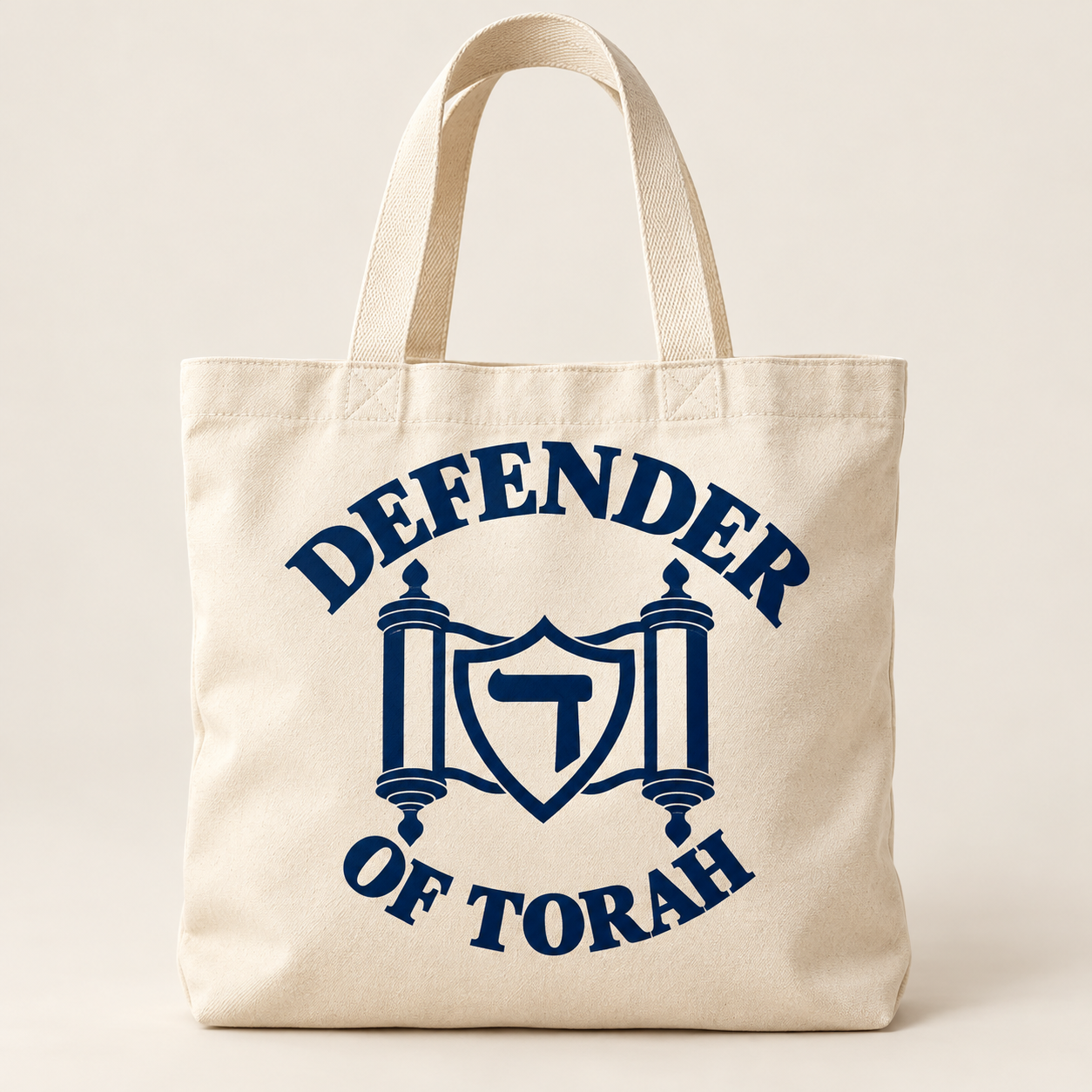 The Everyday Tote in cream / navy, with the Defender of Torah logo